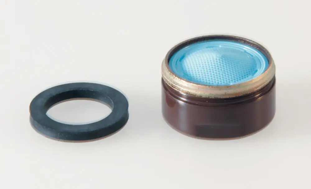 Brauner Strahlregler mit blauer Einsätze und schwarzem Gummiring, produziert von Ideal Standard, für wassersparende Anwendungen im Sanitärbereich.